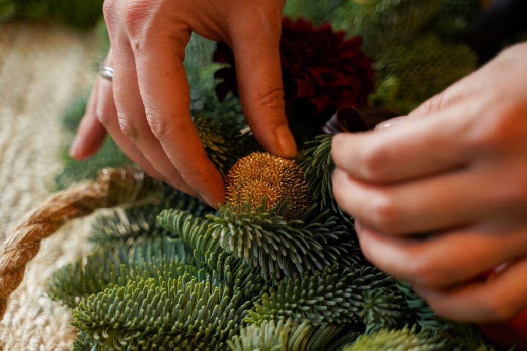 DIY Kerstkrans maken met bloemen - Stap 5 kerstballen toevoegen